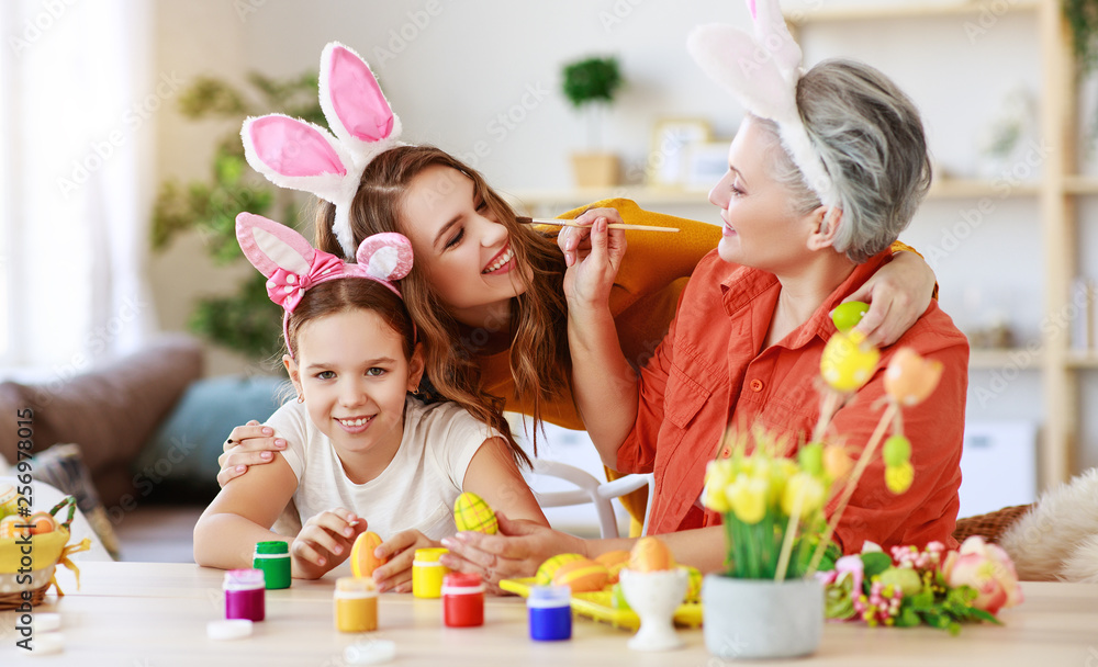 happy Easter! family grandmother, mother and child paint eggs and prepare for holiday.