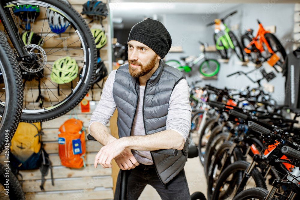 Portrait of a stylish man with folding bicycle at the bicycle shop