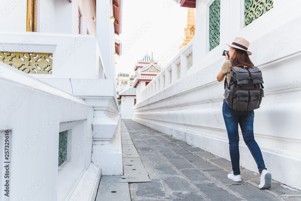 亚洲女子夏季在泰国曼谷美丽的寺庙里旅行，拍照留念