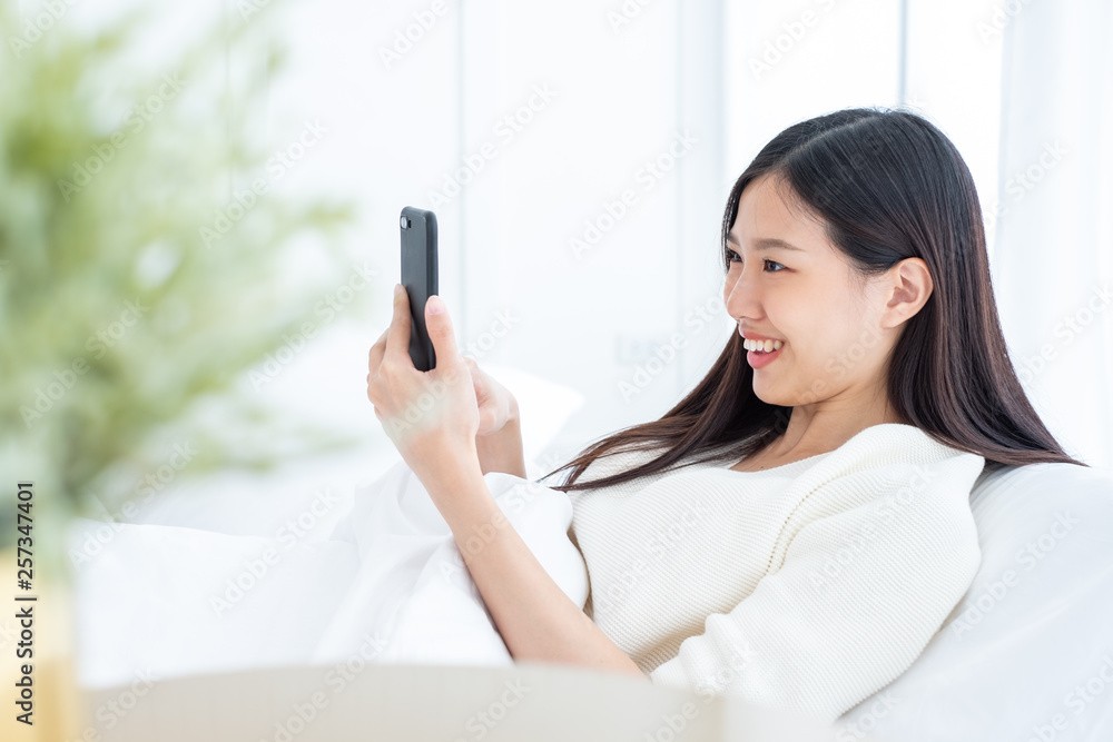 Beautiful Asian woman using smart phone in bed room for online shopping, Asian woman lifestyle conce