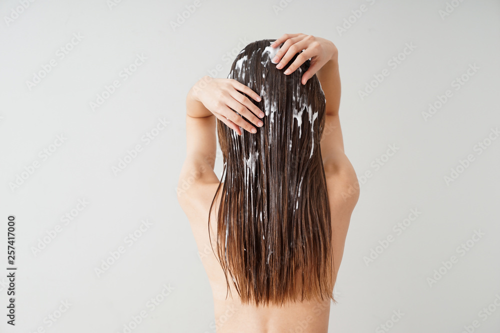 Woman using coconut oil for hair on white background