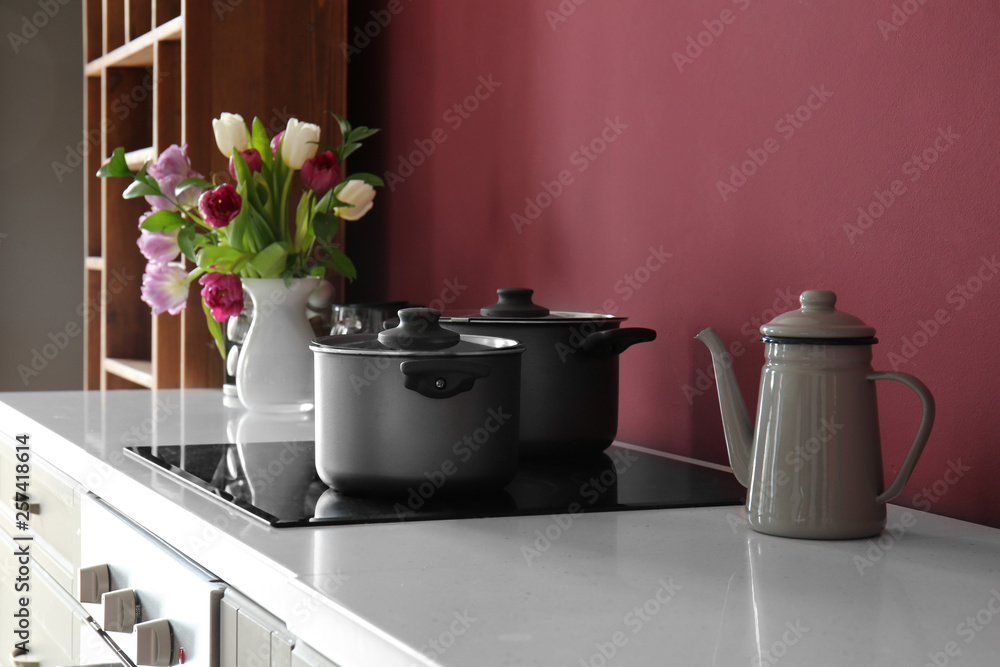 Saucepans on electric stove in modern kitchen