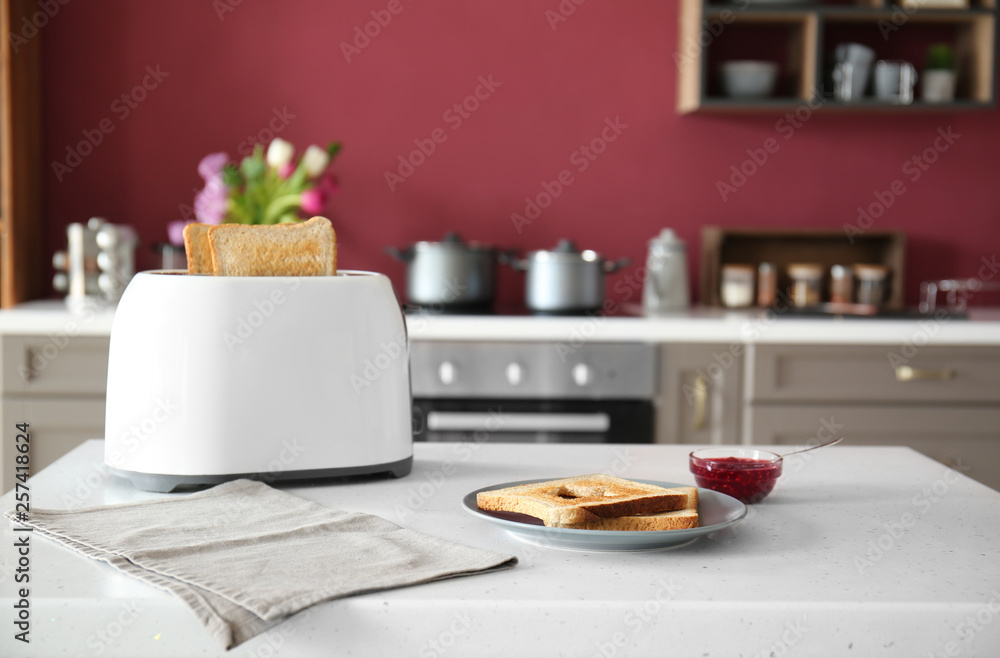 Toaster with bread and jam on table in kitchen