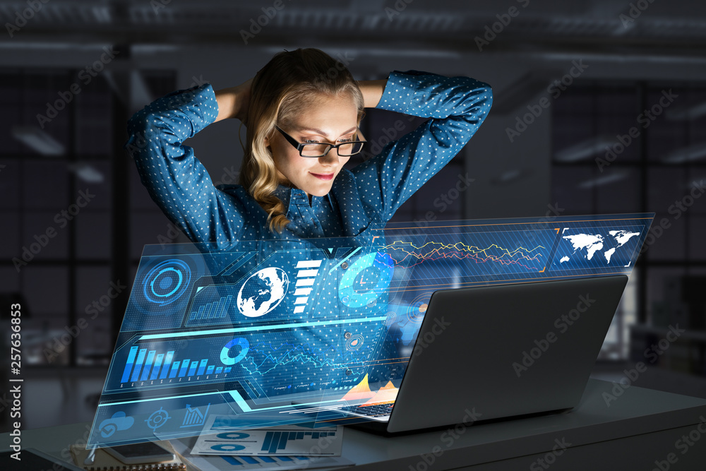 Beautiful blonde working on laptop and infographs out of screen. Mixed media