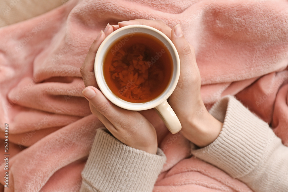 Young woman drinking hot tea at home