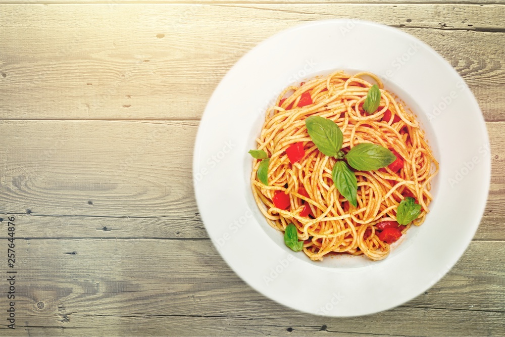 Spaghetti pasta with tomatoes and parsley on  table.