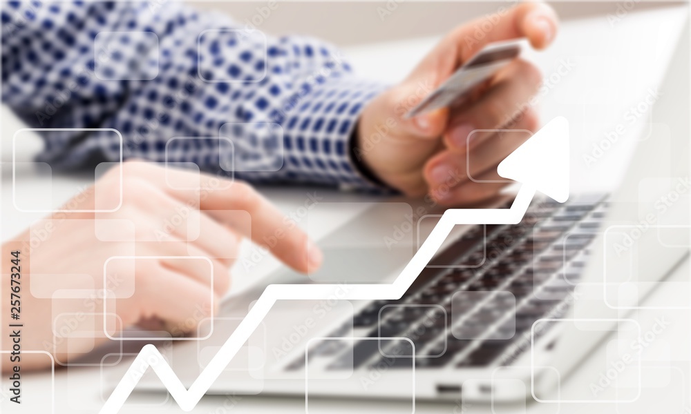 Man holding a credit card and typing. On-line shopping on the internet using a laptop