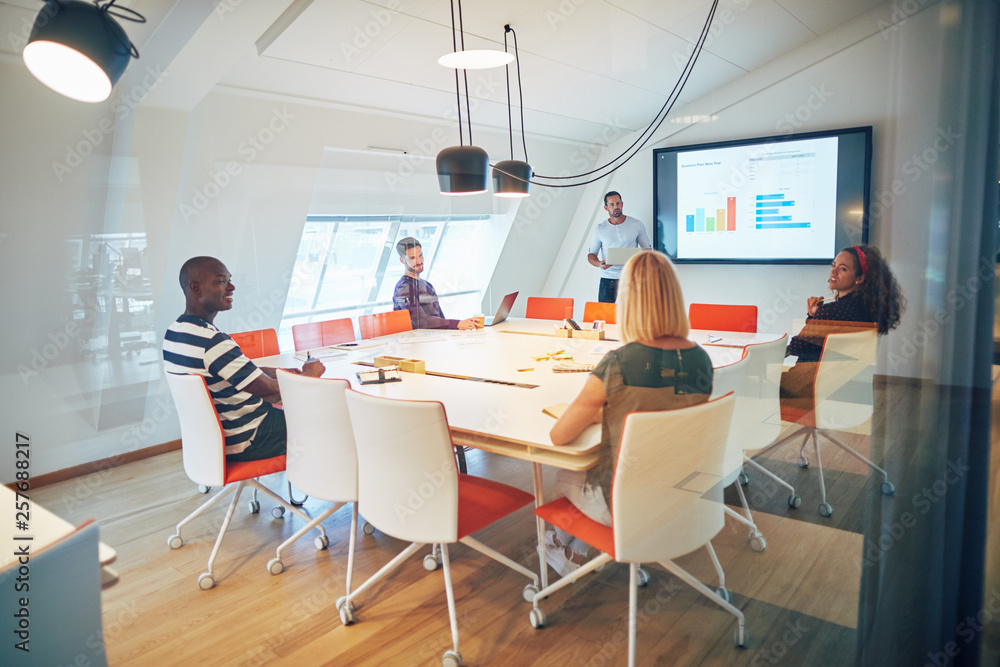 Manager and staff discussing charts together in an office boardr