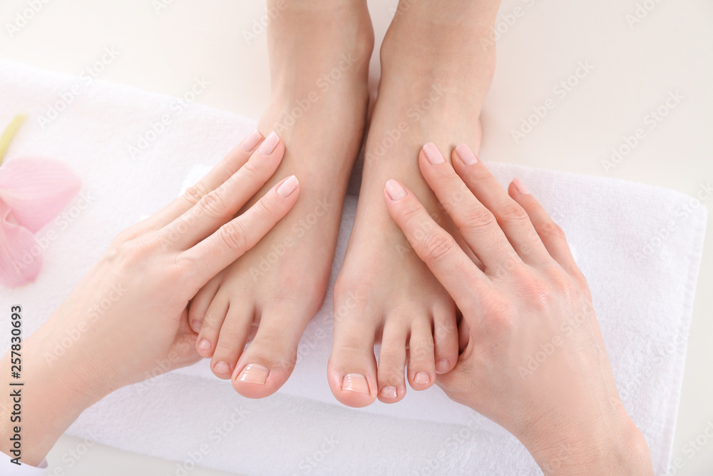 Young woman receiving feet massage in spa salon