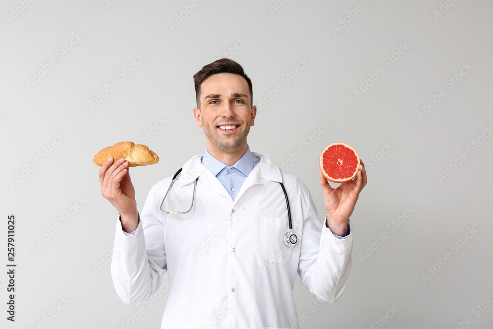 Portrait of male nutritionist on light background