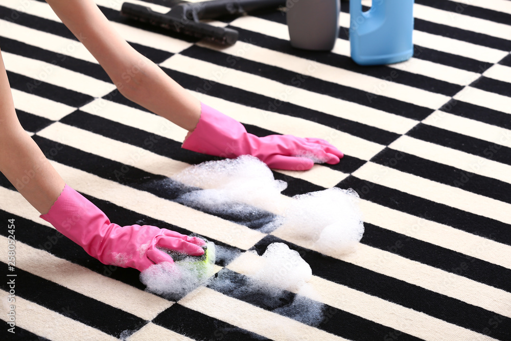 Woman cleaning carpet at home