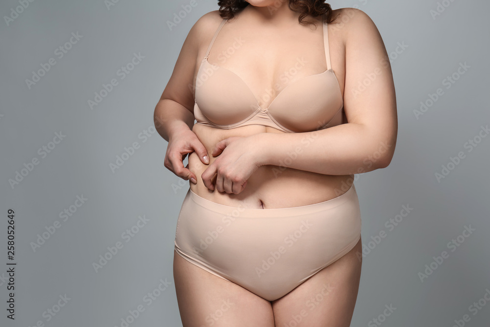 Overweight woman on grey background