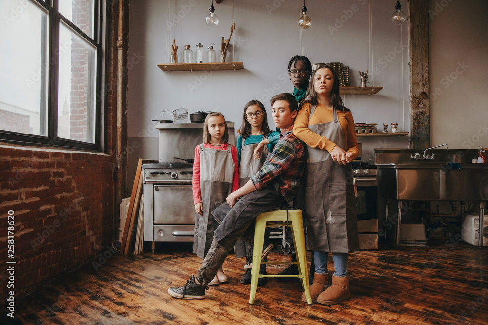 Portrait of serious confident friends wearing aprons in cooking class