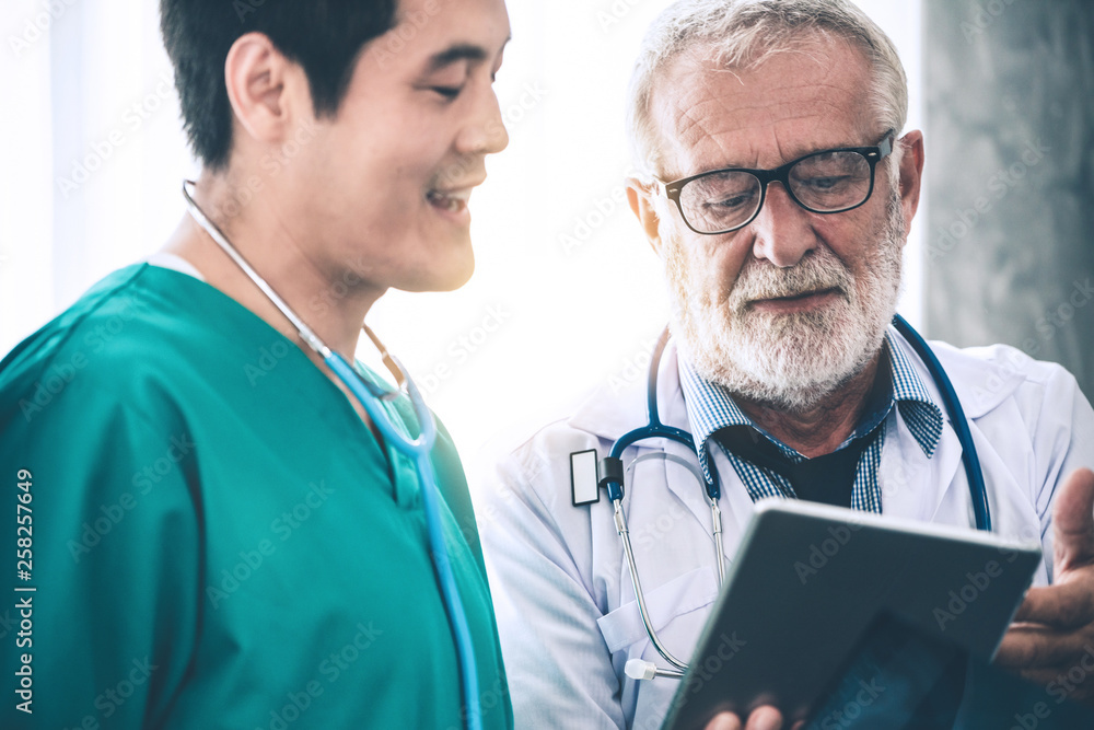 Senior male doctor working with another doctor in hospital. Concept of medical healthcare and doctor