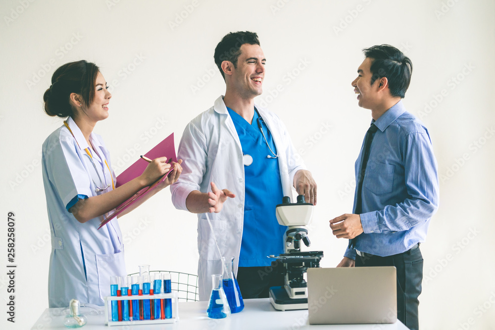 Group of scientists wearing lab coat working in laboratory while examining biochemistry sample in te