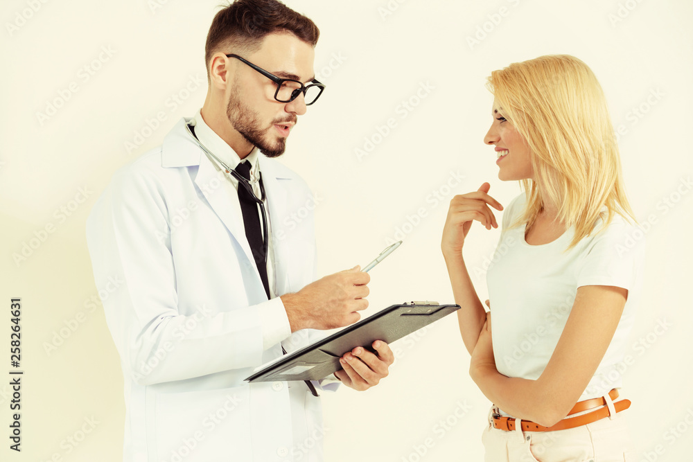 Male doctor and female patient with documents of patients health record are having conversation in h