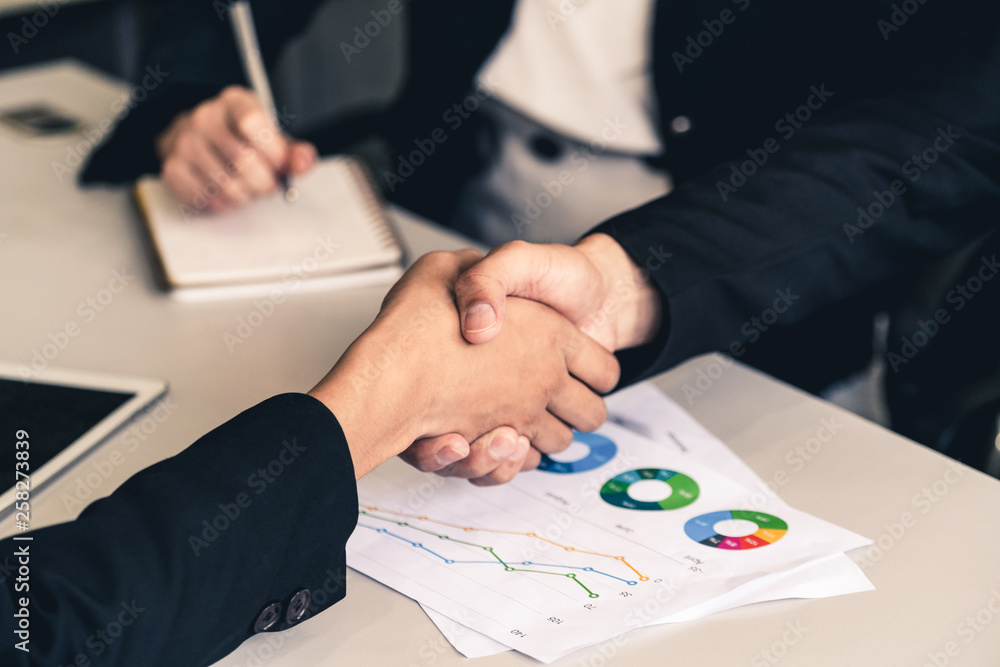 Business people agreement concept. Businessman and Asian businesswoman do handshake in the office.