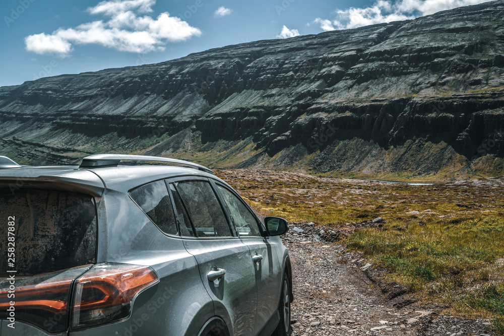 4WD SUV vehicle car running on gravel road with nature mountain landscape in Iceland. Adventure and 