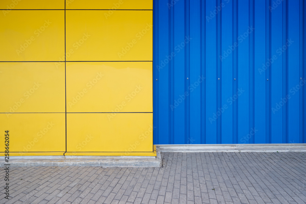 Yellow and blue steel wall with cement ground  background