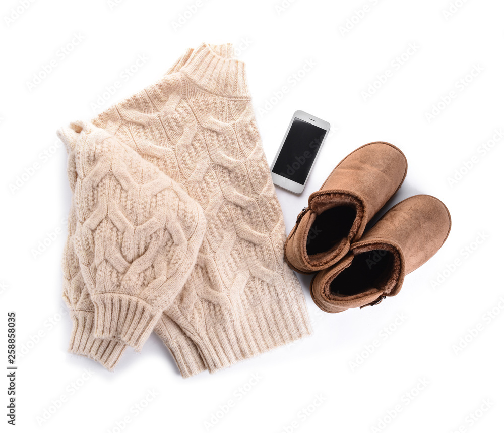 Female boots with sweater and mobile phone on white background