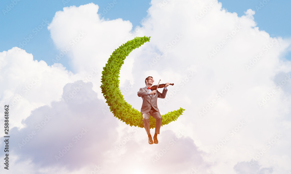 Handsome violinist on moon in blue sky play his melody