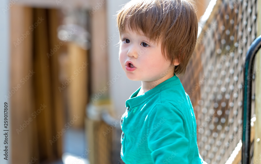 Toddler boy playing outside at a playground