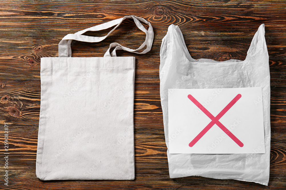 Plastic and fabric bags on wooden background. Ecology concept