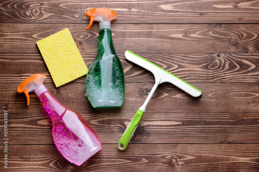 Set of cleaning supplies on wooden background