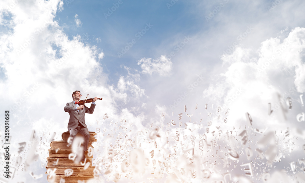 Handsome violinist play his melody and symbols fly around in air