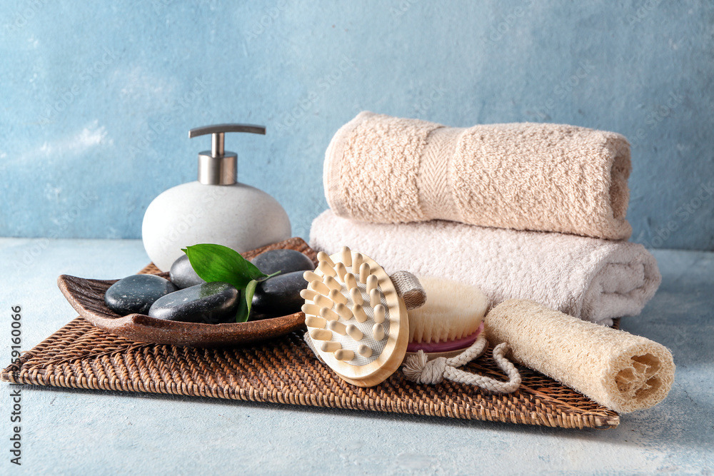 Massage brushes with towels and spa stones on table