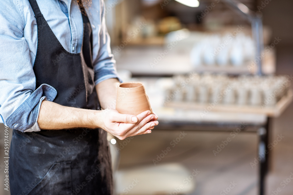 Potter with ceramic jug at the pottery shop