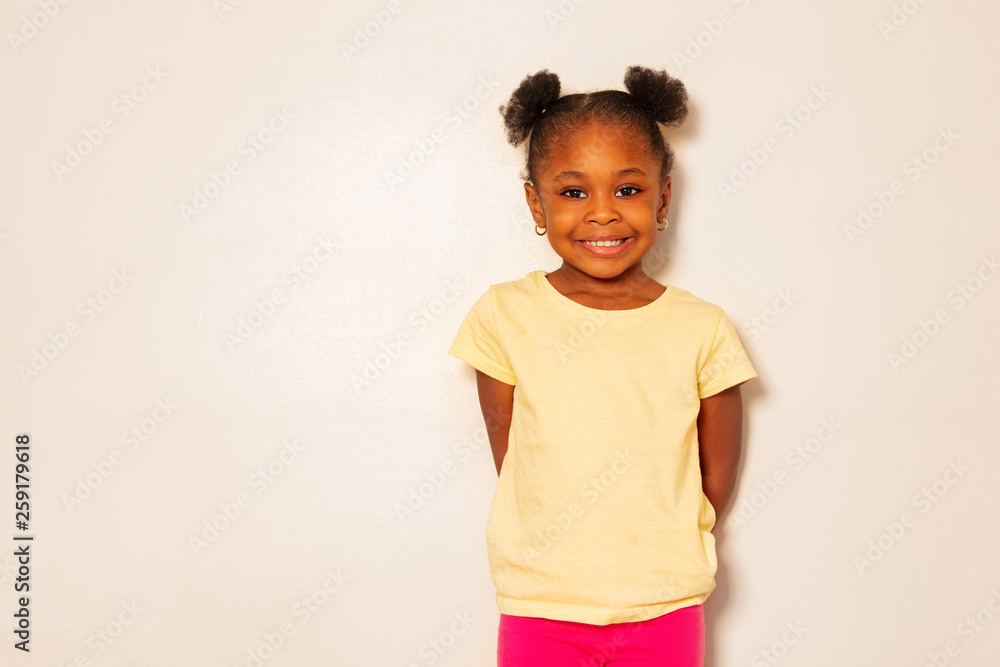 Portrait of nice little black girl smile over wall