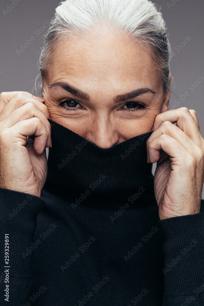 Mature woman covering her face with top