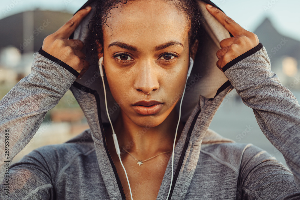 Confident female runner in a hoodie