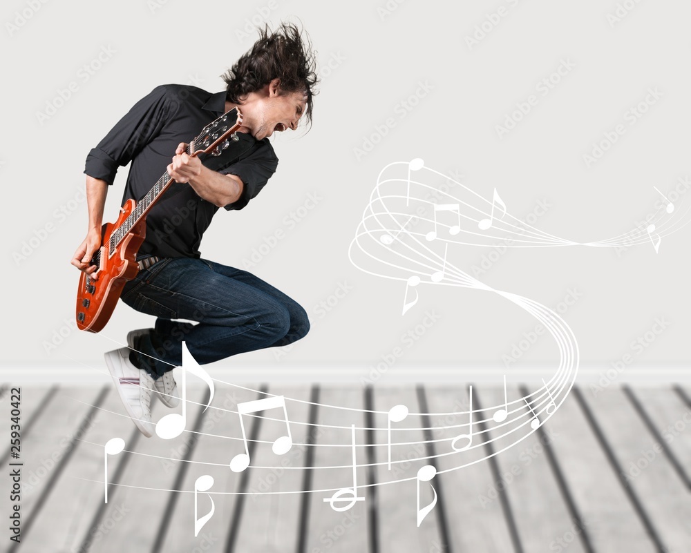 Portrait of a Musician Jumping while Playing an Electric Guitar