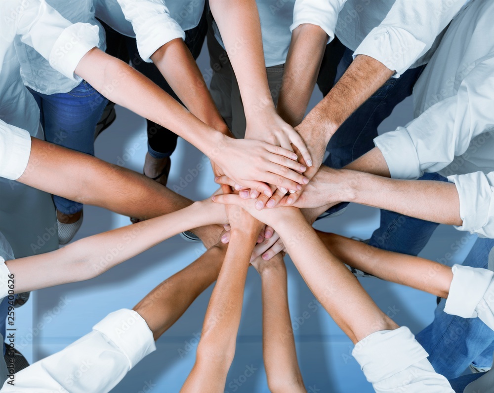 Group of people stacking hands together