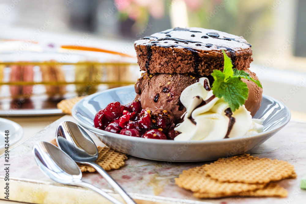 Fresh chocolate ice cream with brownie and cherry jam