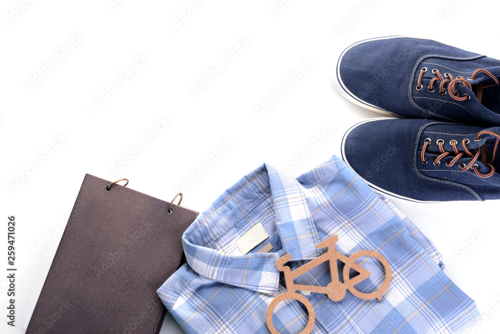 Shirt, shoes, notebook and figure of bicycle on white background. Travel concept