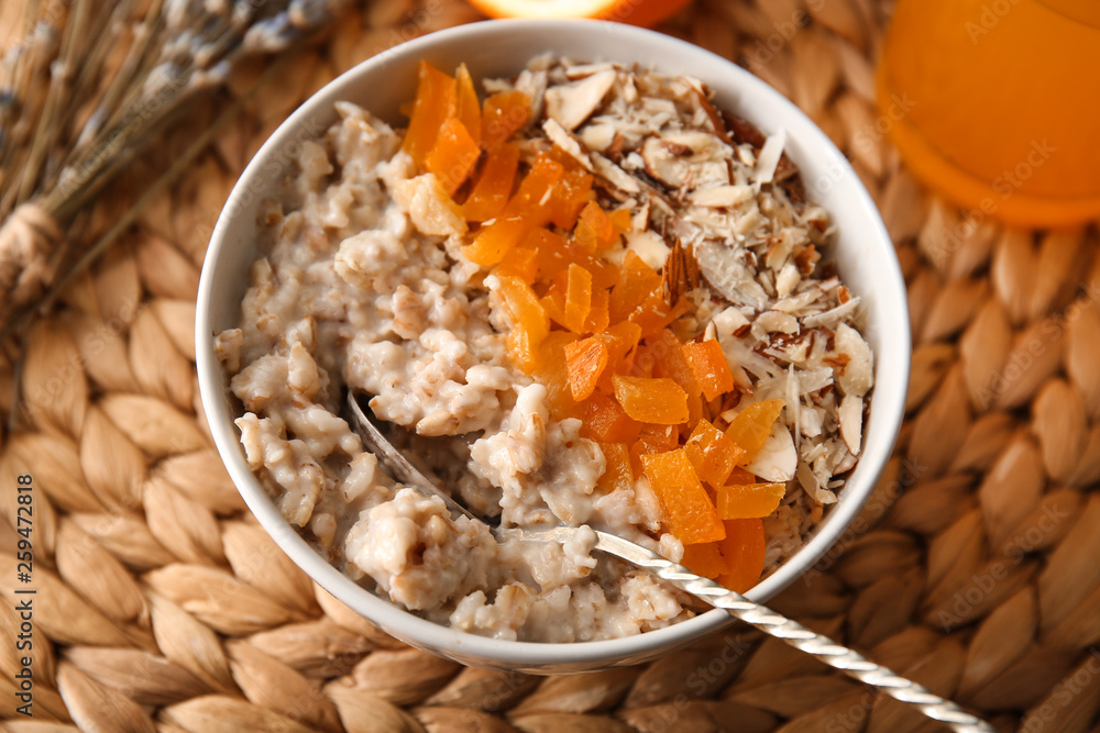 Bowl with tasty sweet oatmeal on table