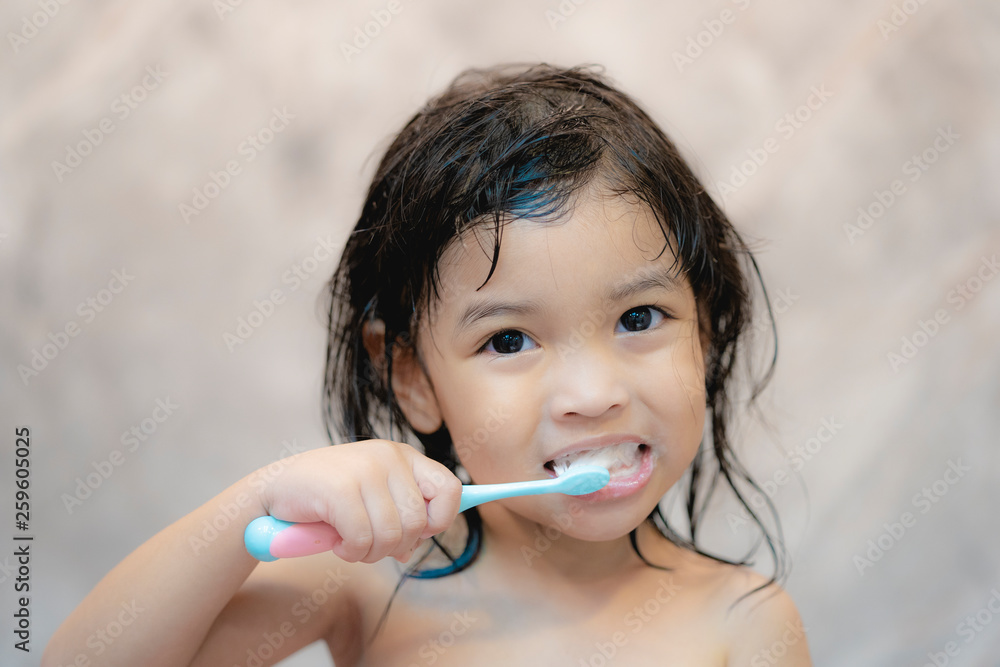 Dental hygiene. Asian cute girl or kid brushing her teeth by toothbrush in the bathroom. Healthcare 