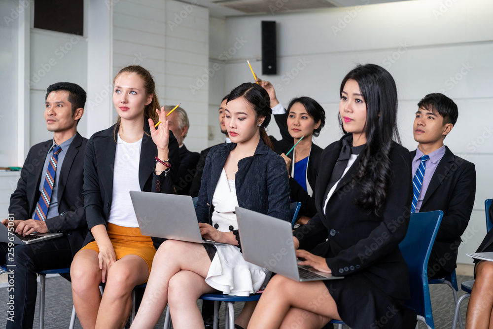 Young Asian and Caucasian audience sitting and listen to speaker in group meeting presentation at th