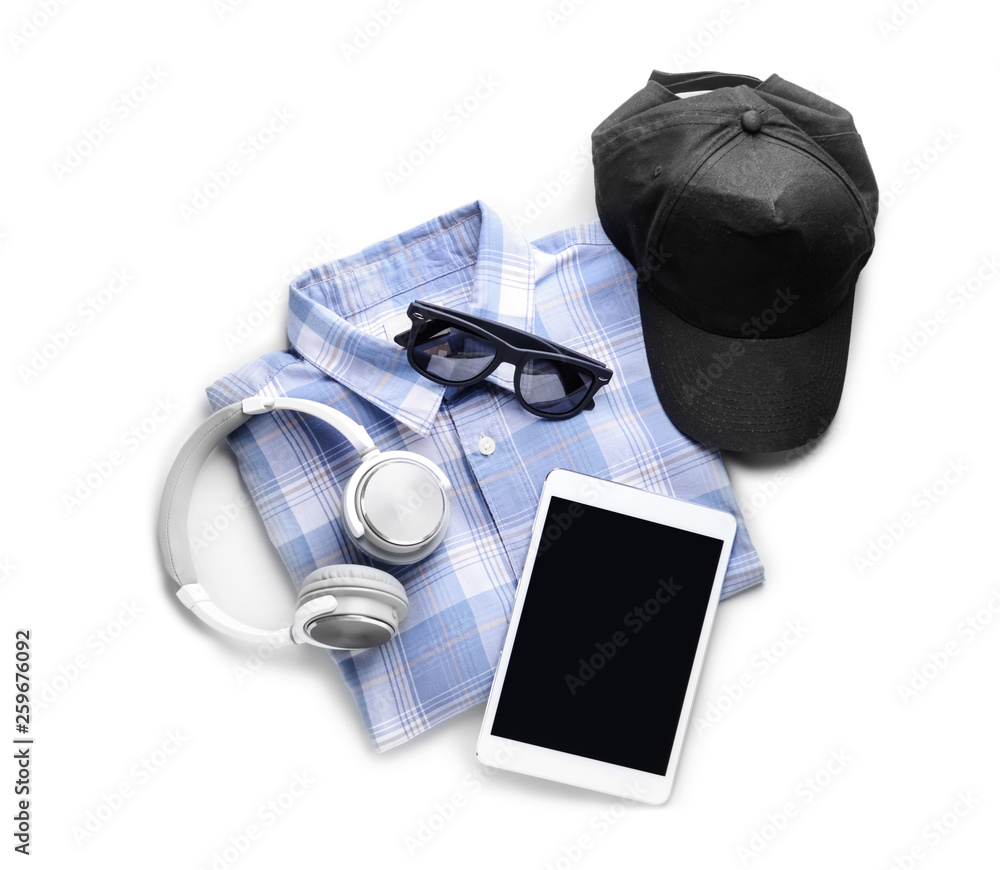 Shirt with cap, tablet PC, sunglasses and headphones on white background