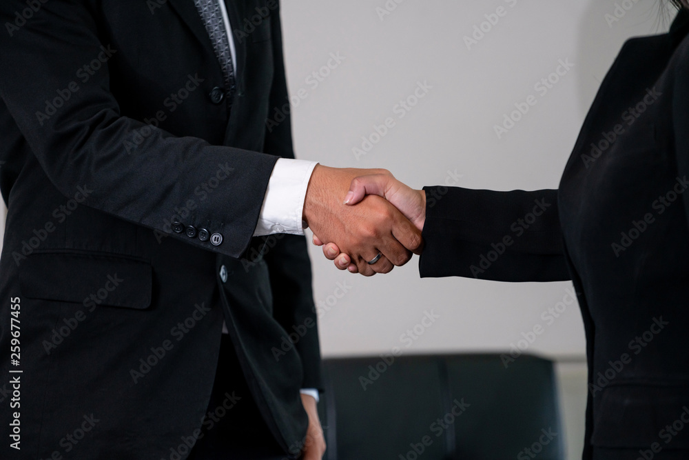 Business people agreement concept. Businessman and Asian businesswoman do handshake in the office.