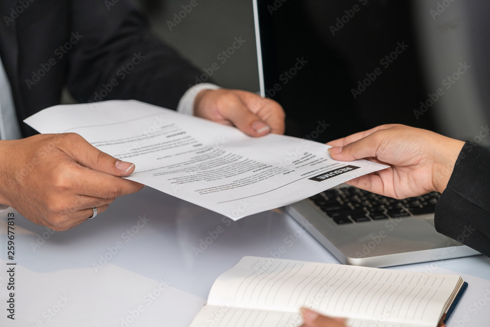 Close up view of employee candidate hands CV resume document to the interviewer HR human resources d