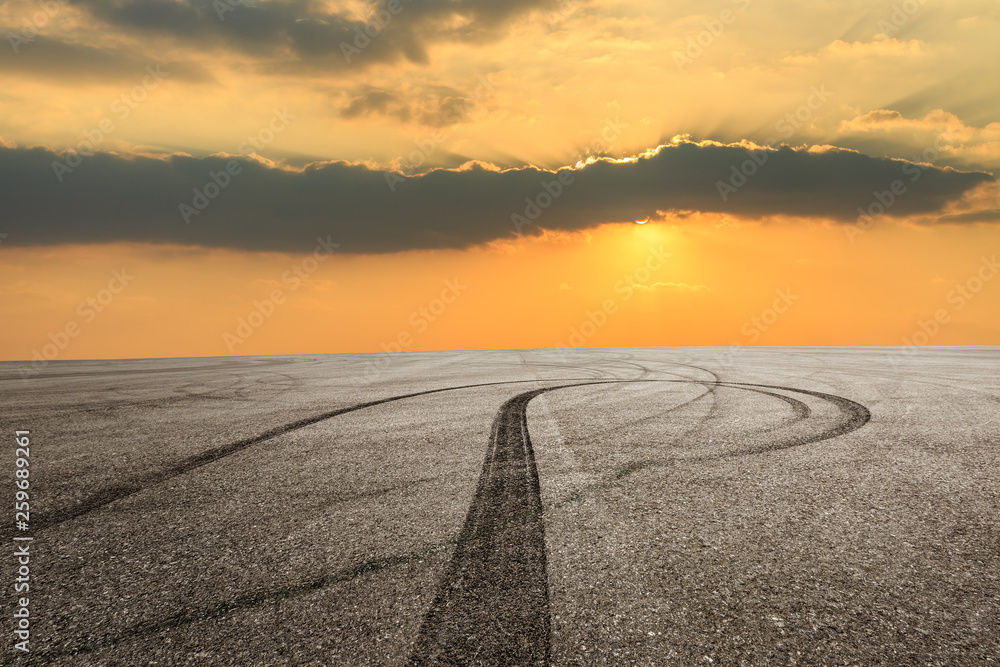 Asphalt race track ground and beautiful sky clouds at sunset