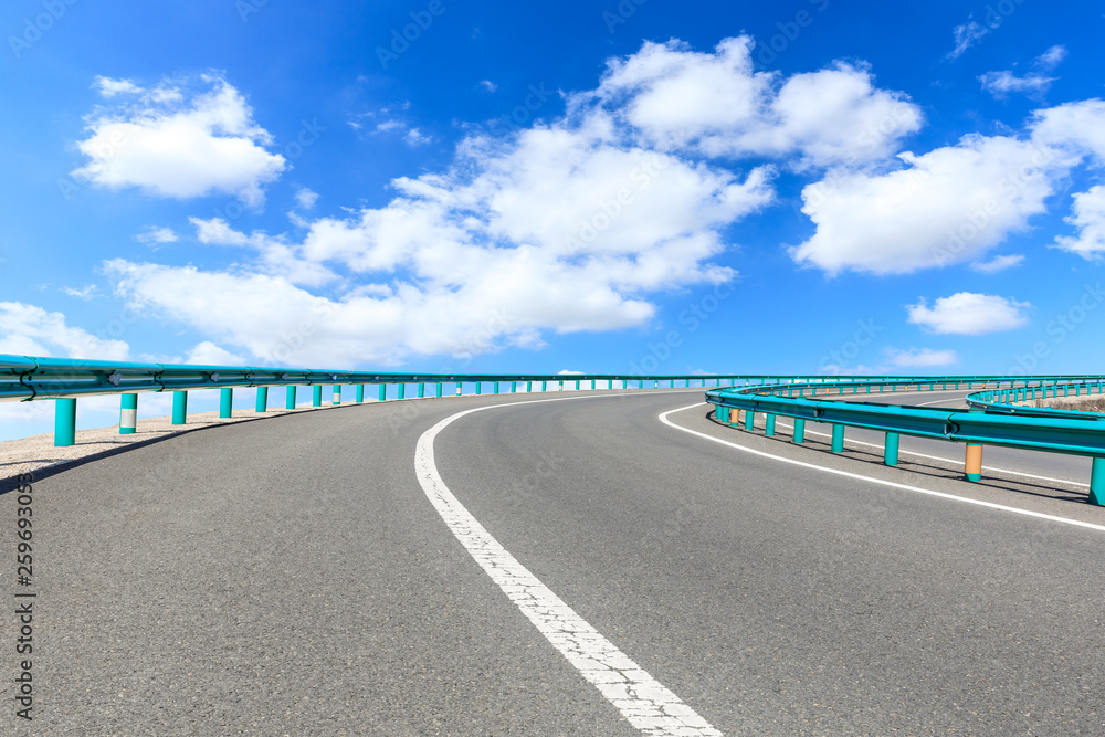 Empty asphalt road and blue sky with white clouds scene