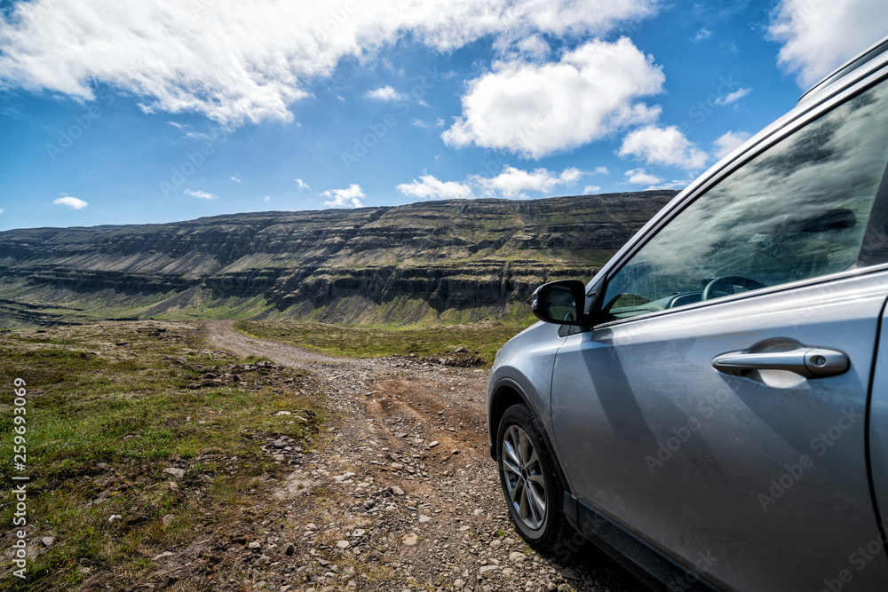 4WD SUV vehicle car running on gravel road with nature mountain landscape in Iceland. Adventure and 