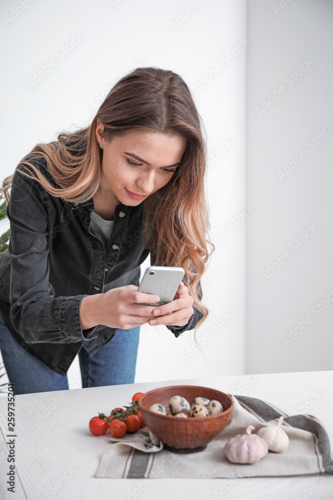 女美食摄影师拿着手机在家拍美食