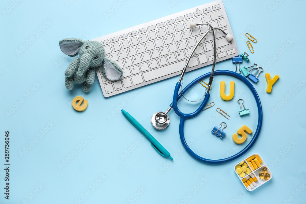 Composition with PC keyboard, stethoscope and toy on color background