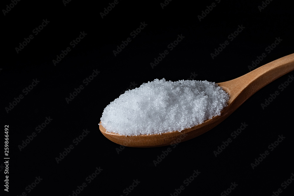 a spoonful of fine salt on a black background